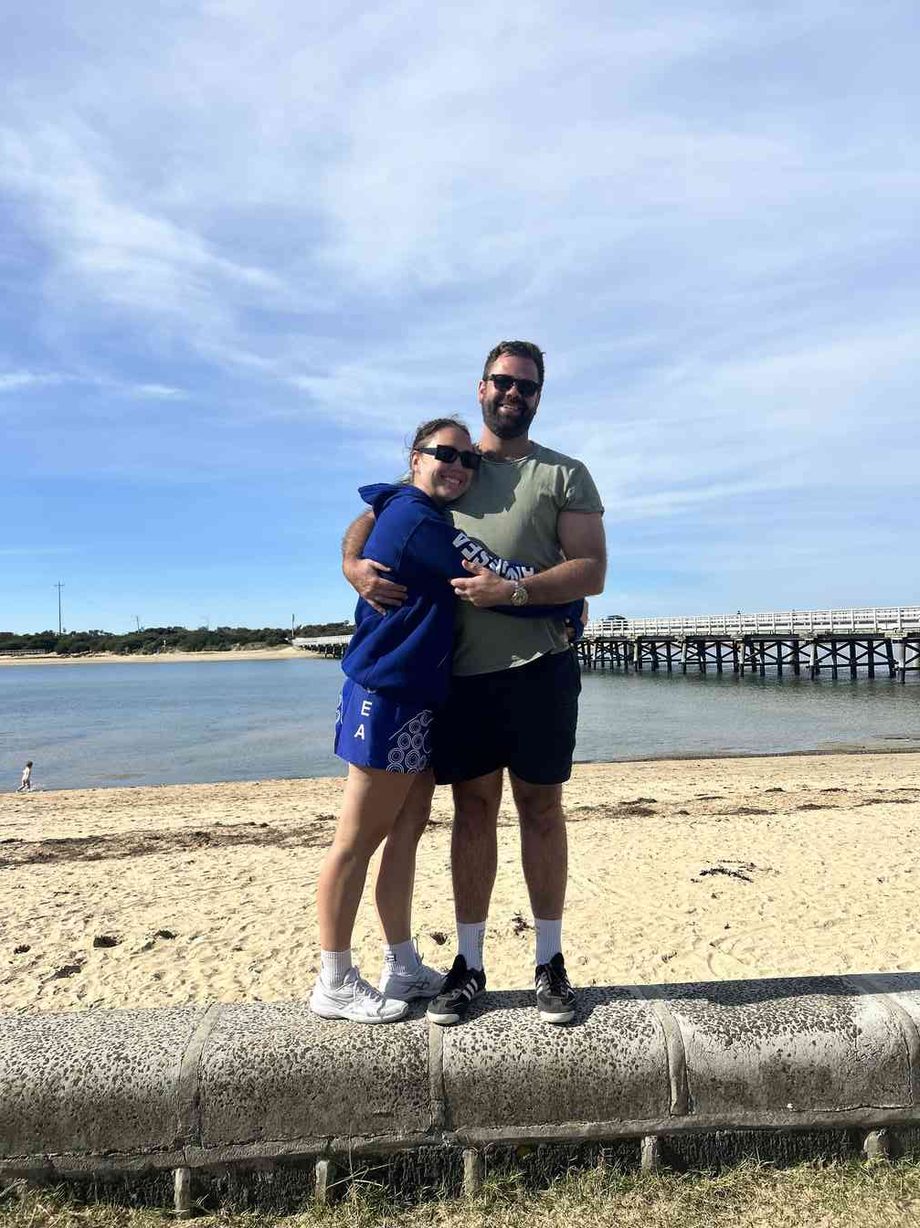 Danielle and Jordan on the beach at Anglesea, the pier behind them